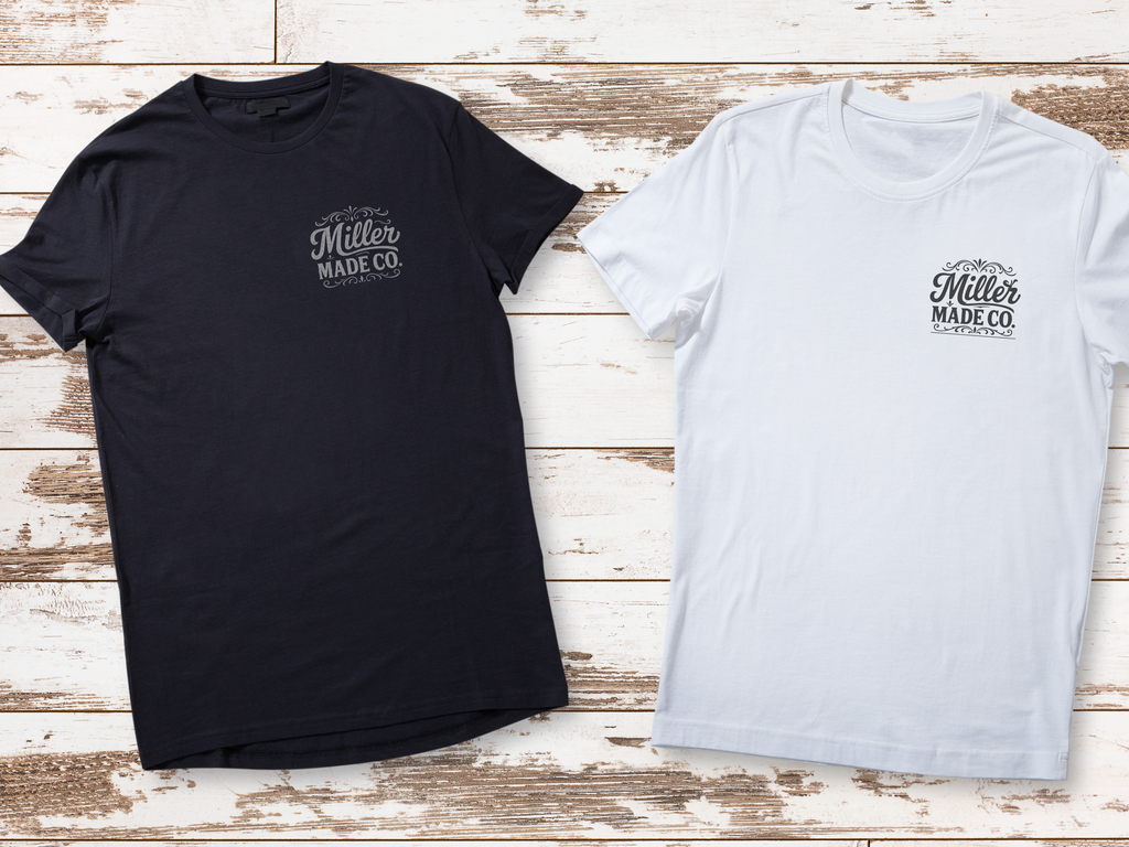 Black and white t-shirts with 'Miller Made Co.' logo on a wooden surface